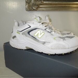 New Balance 530 sneakers in a white and silver colorway with yellow accents.